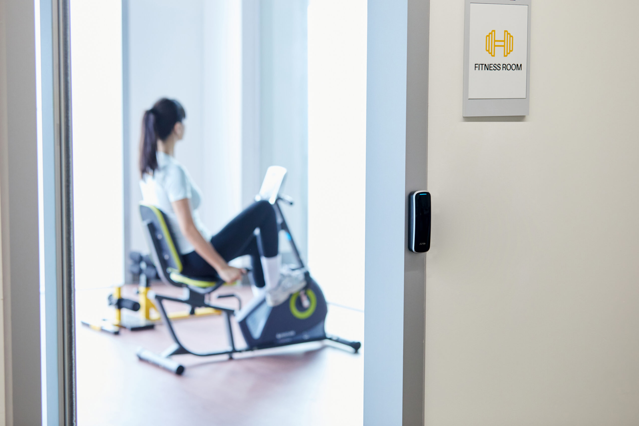 Man and woman using exercise equipment at a gym